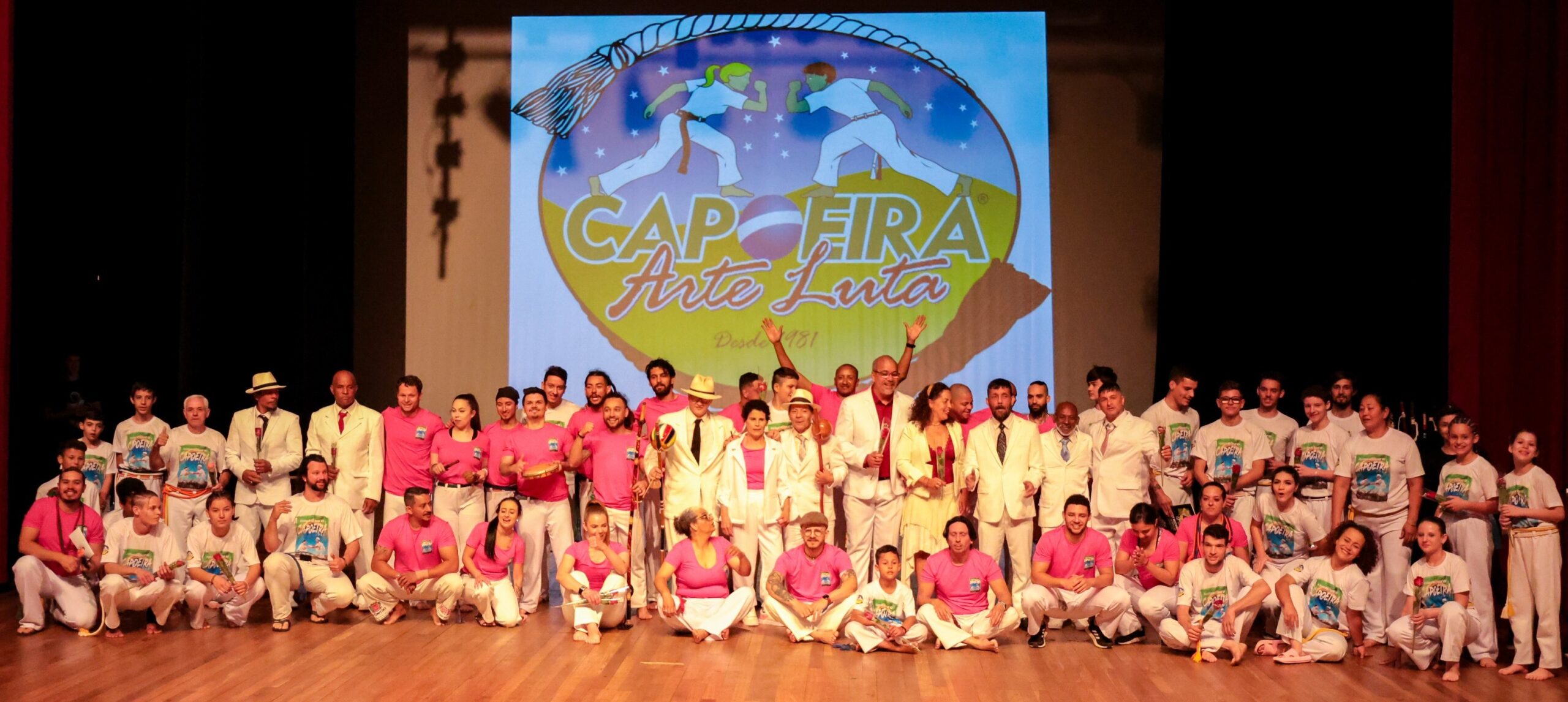 Grupo da Capoeira Arte Luta reunido no palco durante apresentação